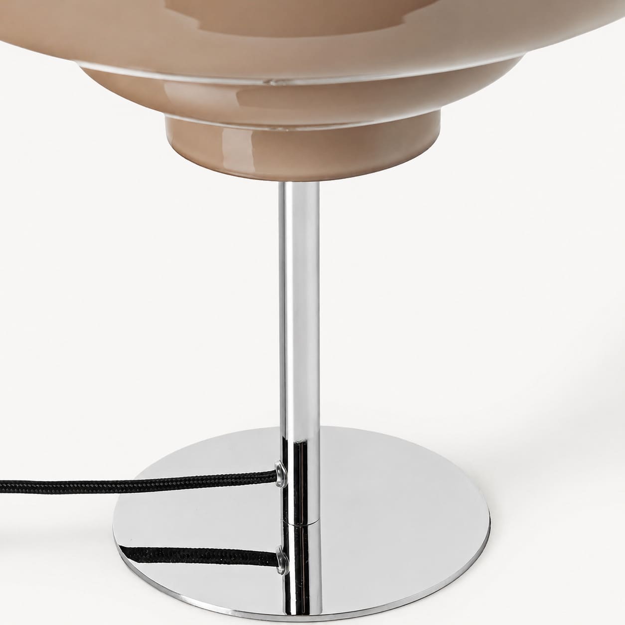 Detail of the glass shade, chrome base, and black cable