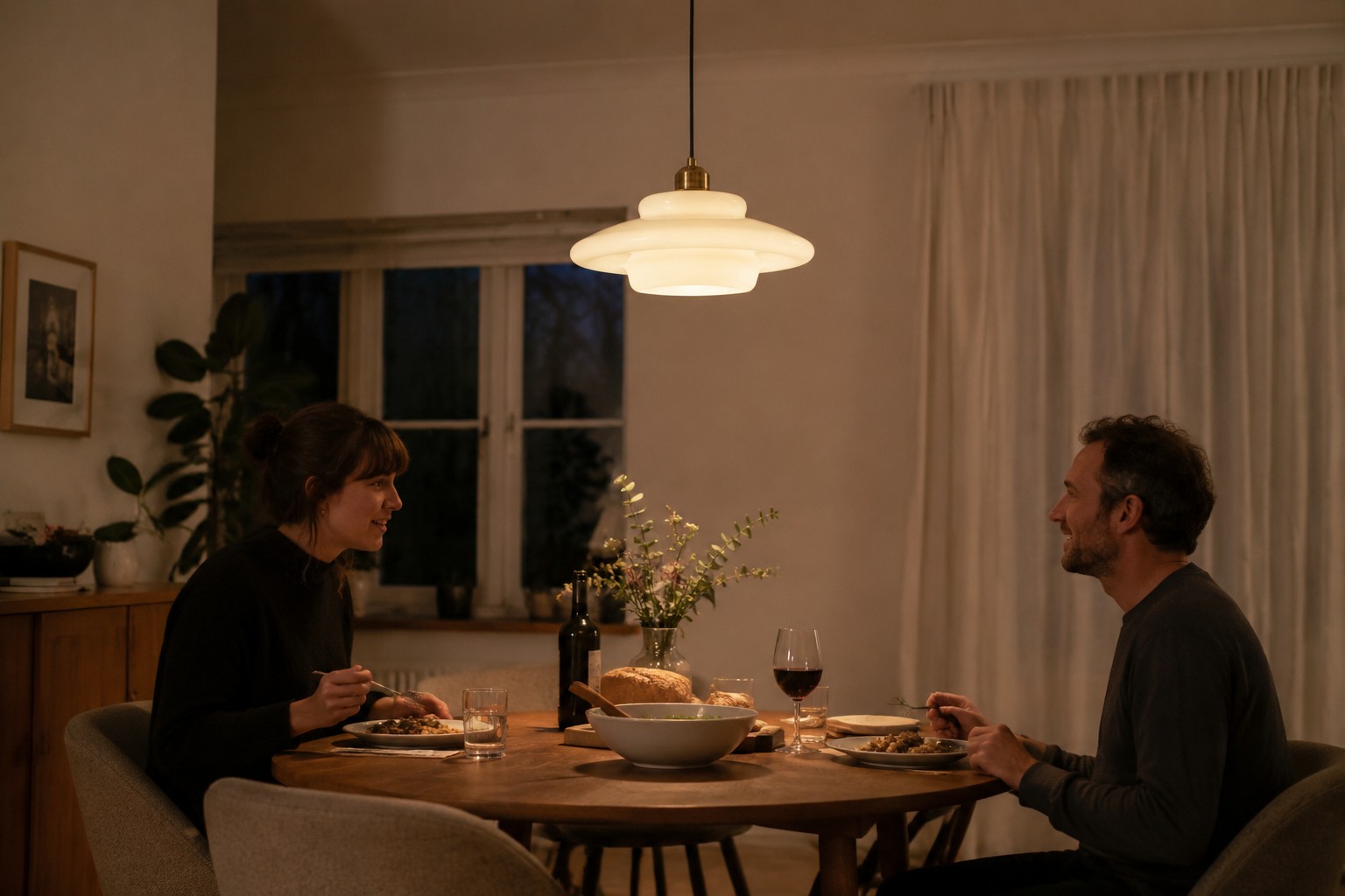 Milk white glass pendant spreading soft diffused light around a dining table