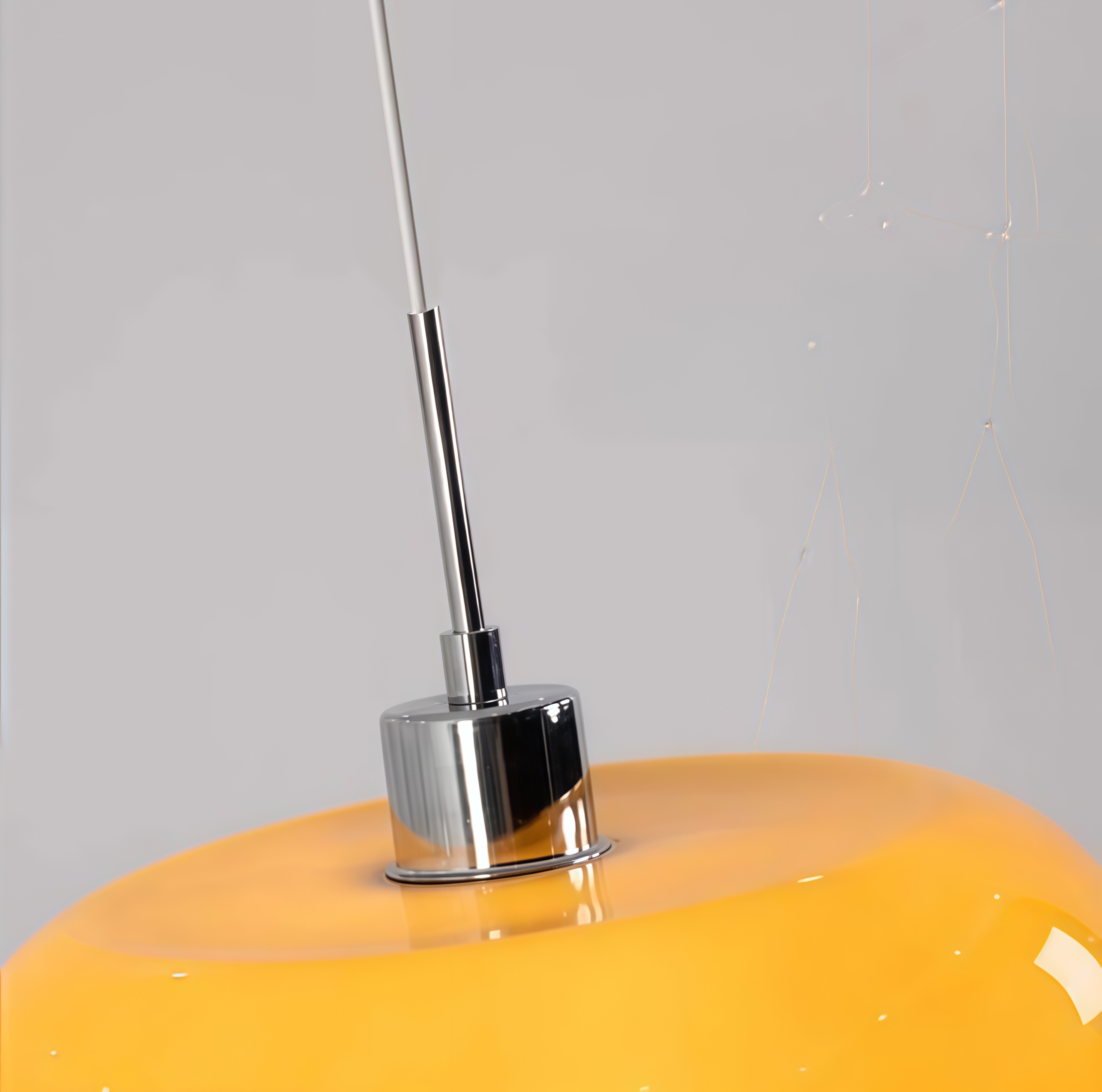 Metal suspension detail on round glass pendant light