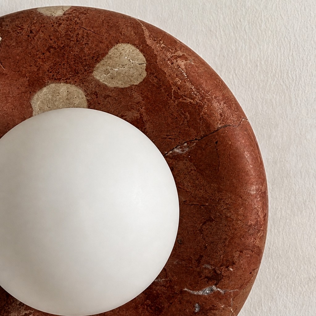 Close view of red travertine and round glass shade