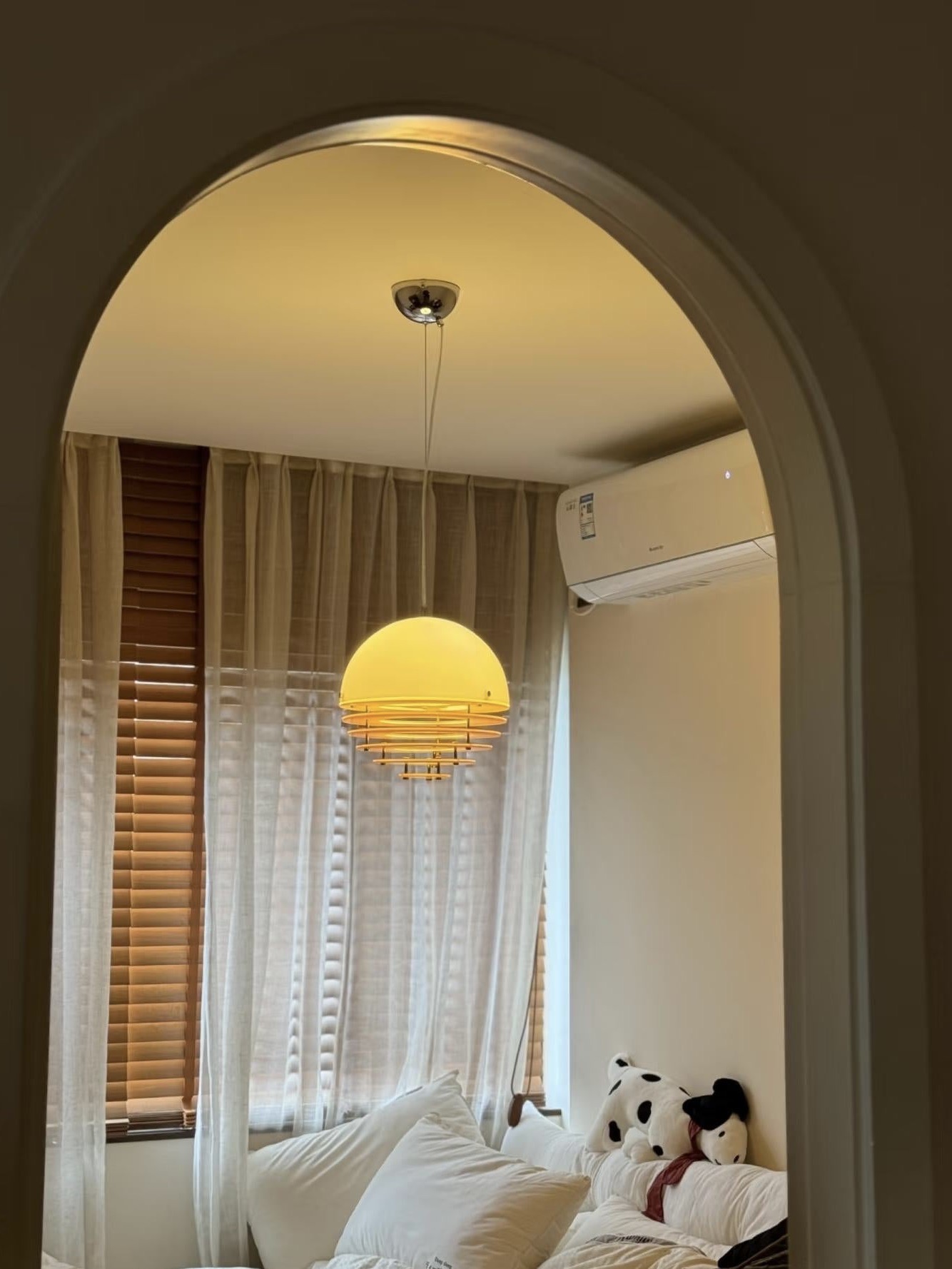 Warm pendant light viewed through an arched doorway