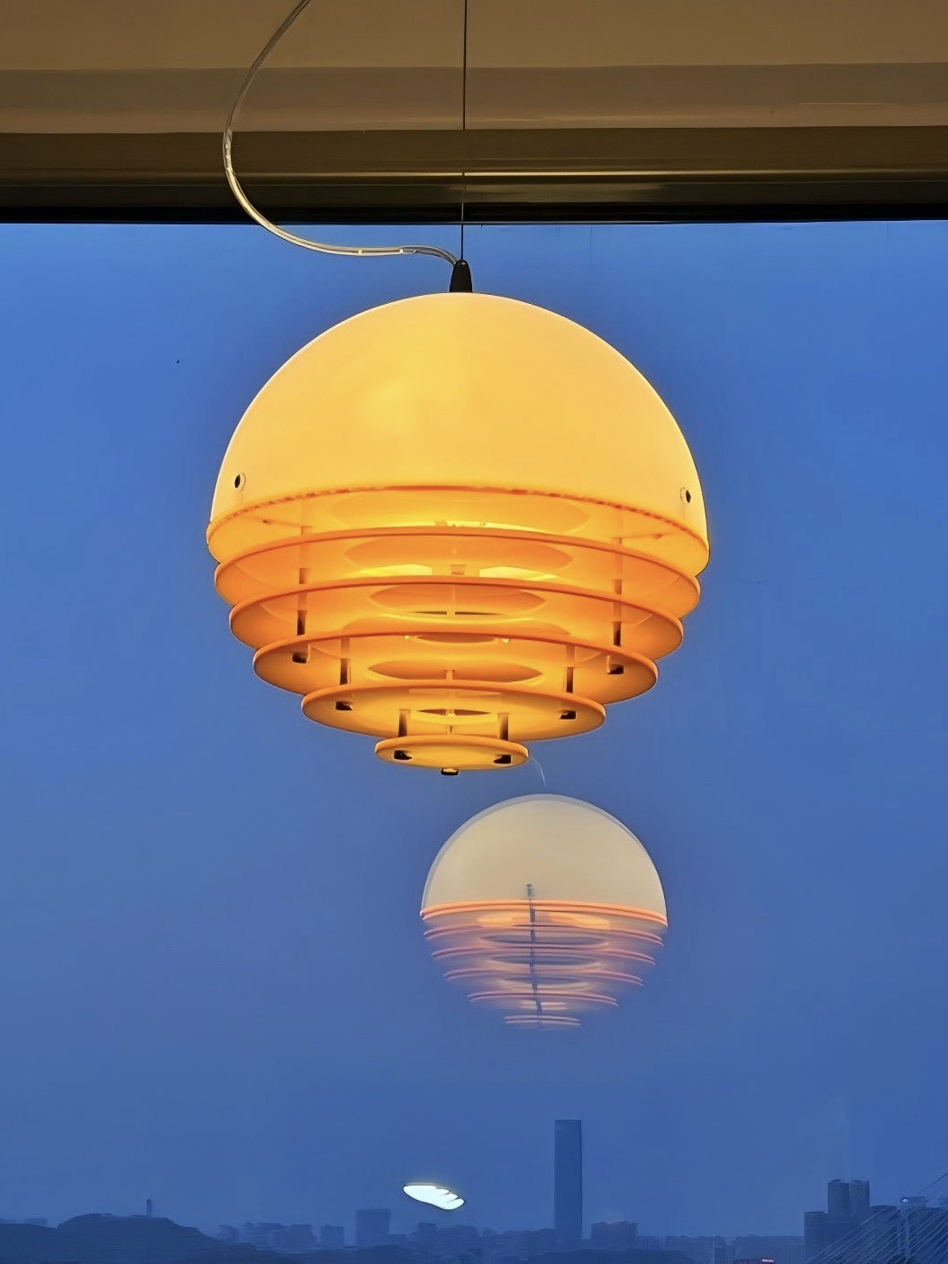 Pendant light reflected against an evening sky