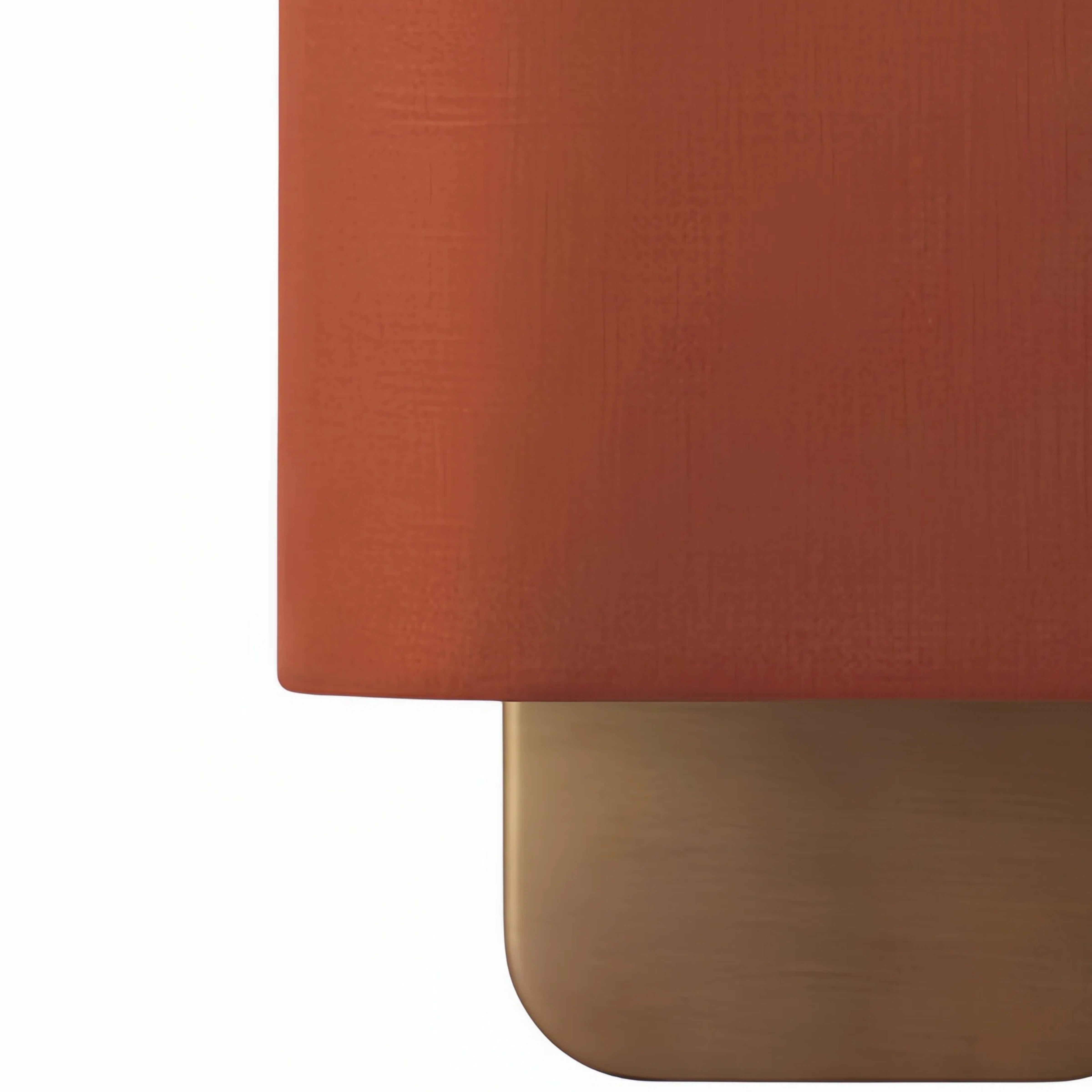 Close-up of red fabric shade and bronze metal base
