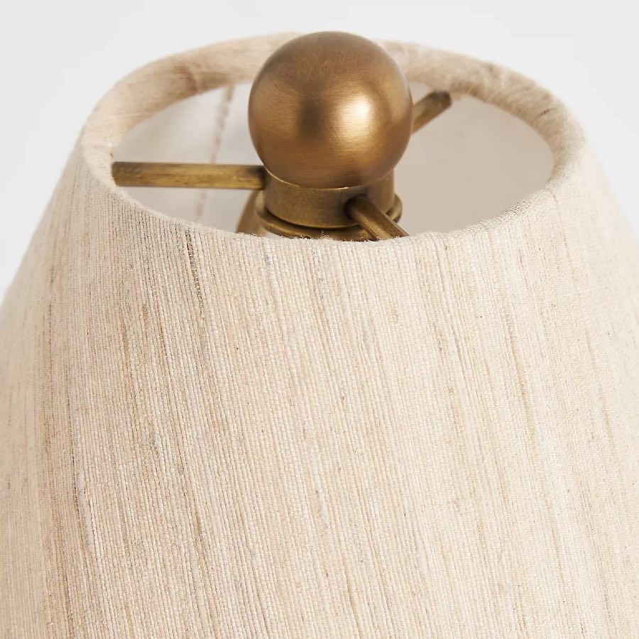 Close view of linen shade and antique brass finial