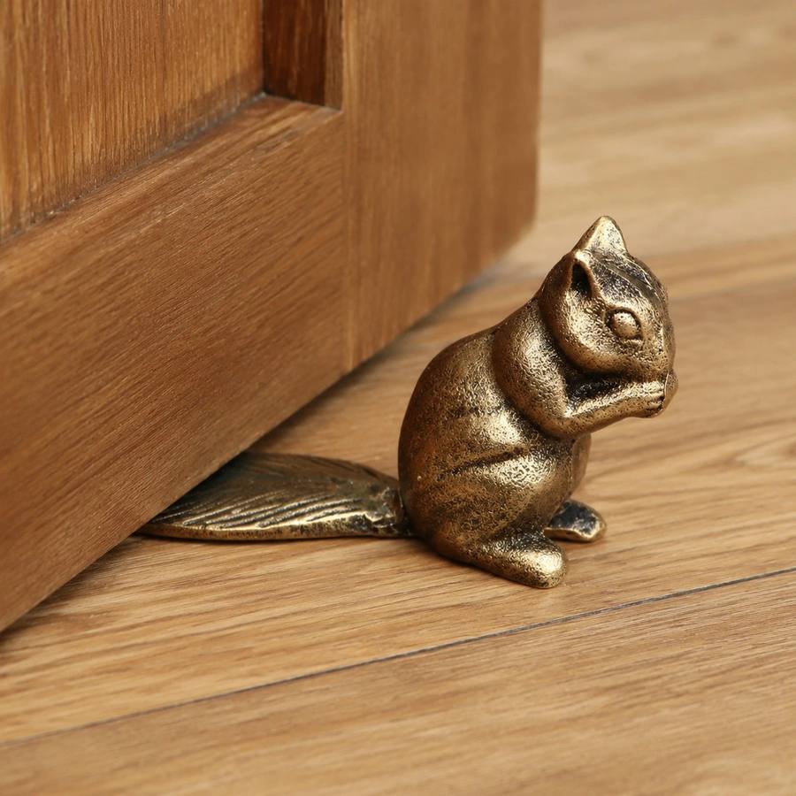 Bronze Guardian door stopper holding a wood door open