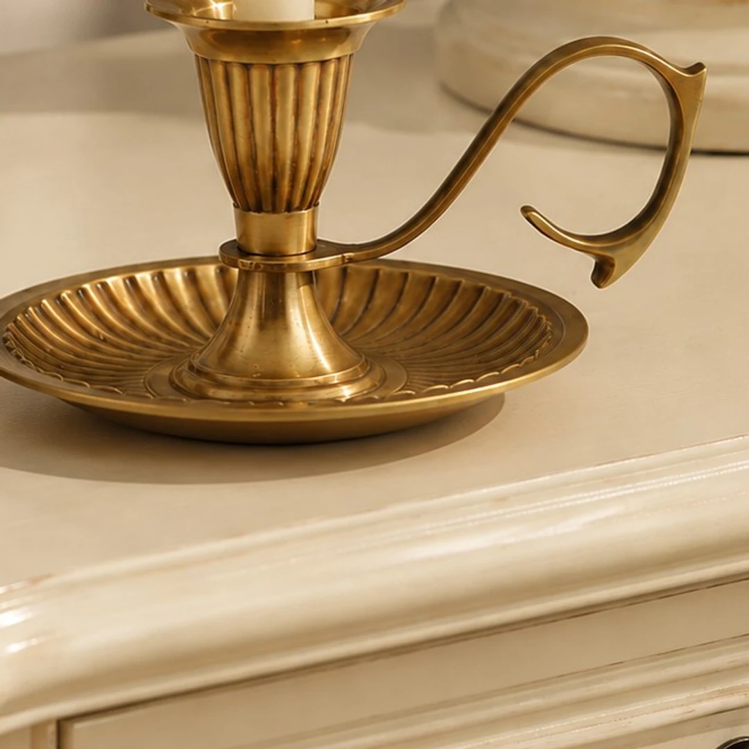 Ribbed tray base and curled handle profile of the Aura candlestick