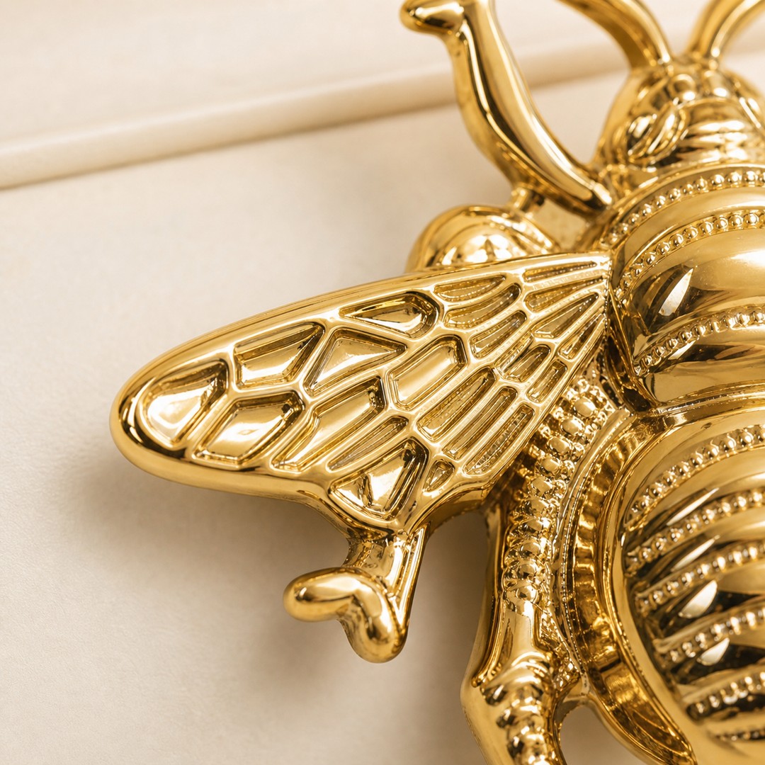 Gold cabinet handle macro detail showing wing texture