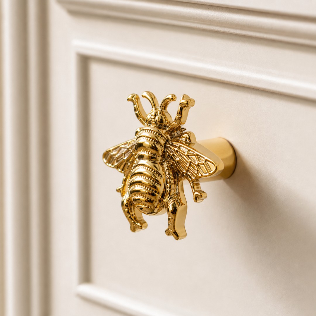 Gold bee cabinet handle close-up showing the full sculptural form