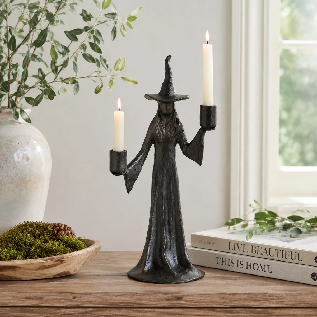 Aura double candle black resin candlestick styled on a tabletop with lit taper candles