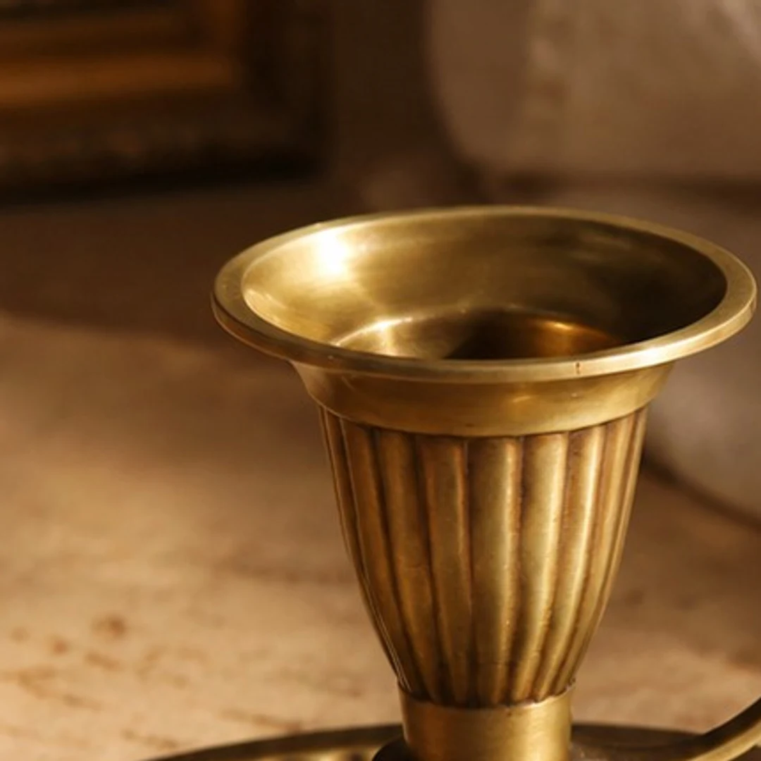 Open brass cup rim and ribbed texture detail on the Aura candlestick