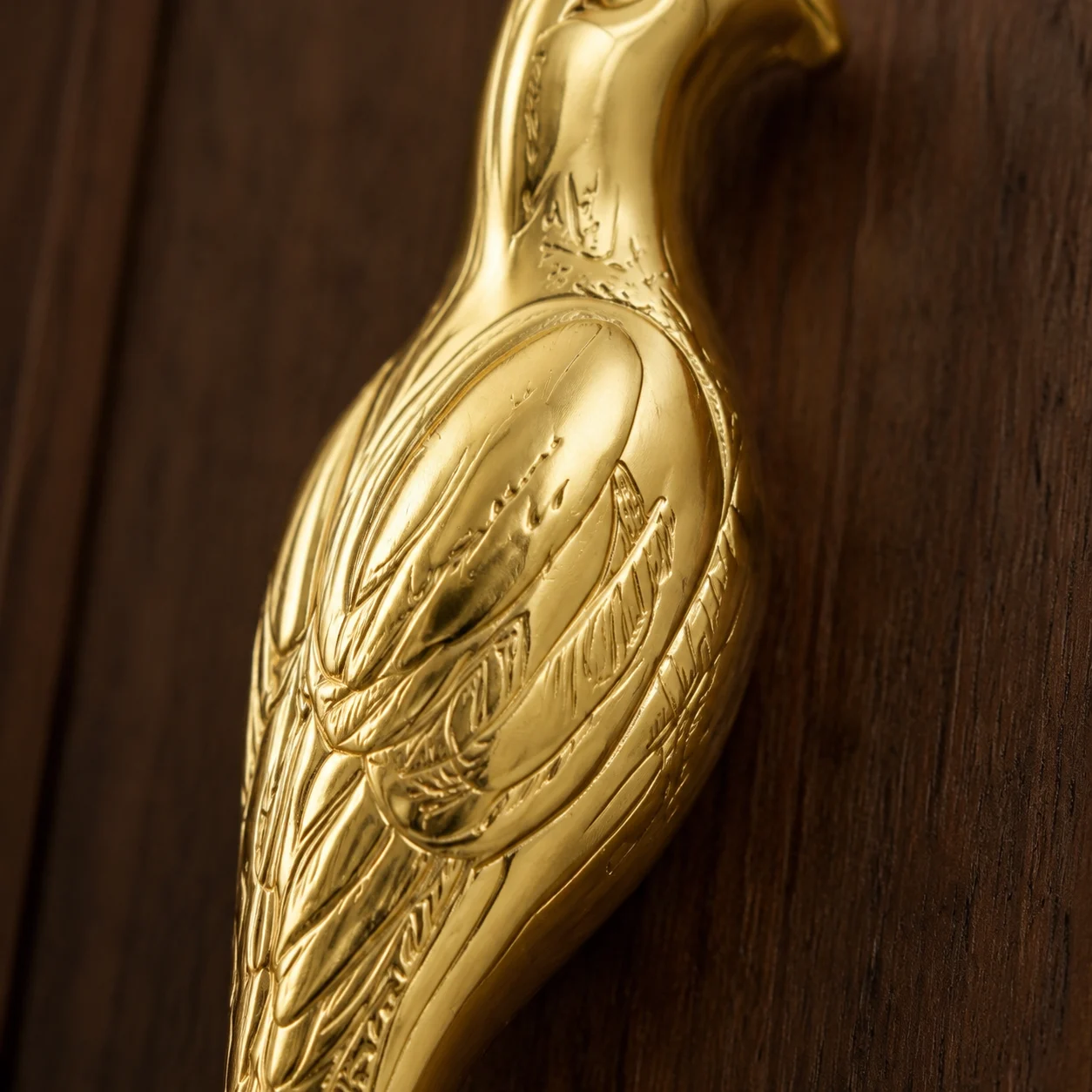 Macro detail of the carved brass relief on the Totem handle