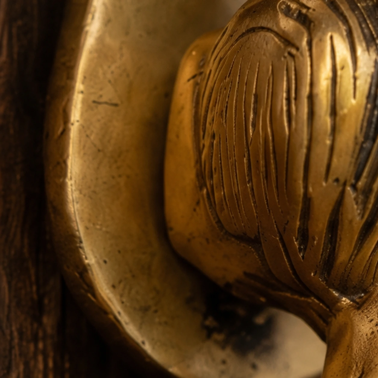 Zoomed detail crop of the carved brass surface