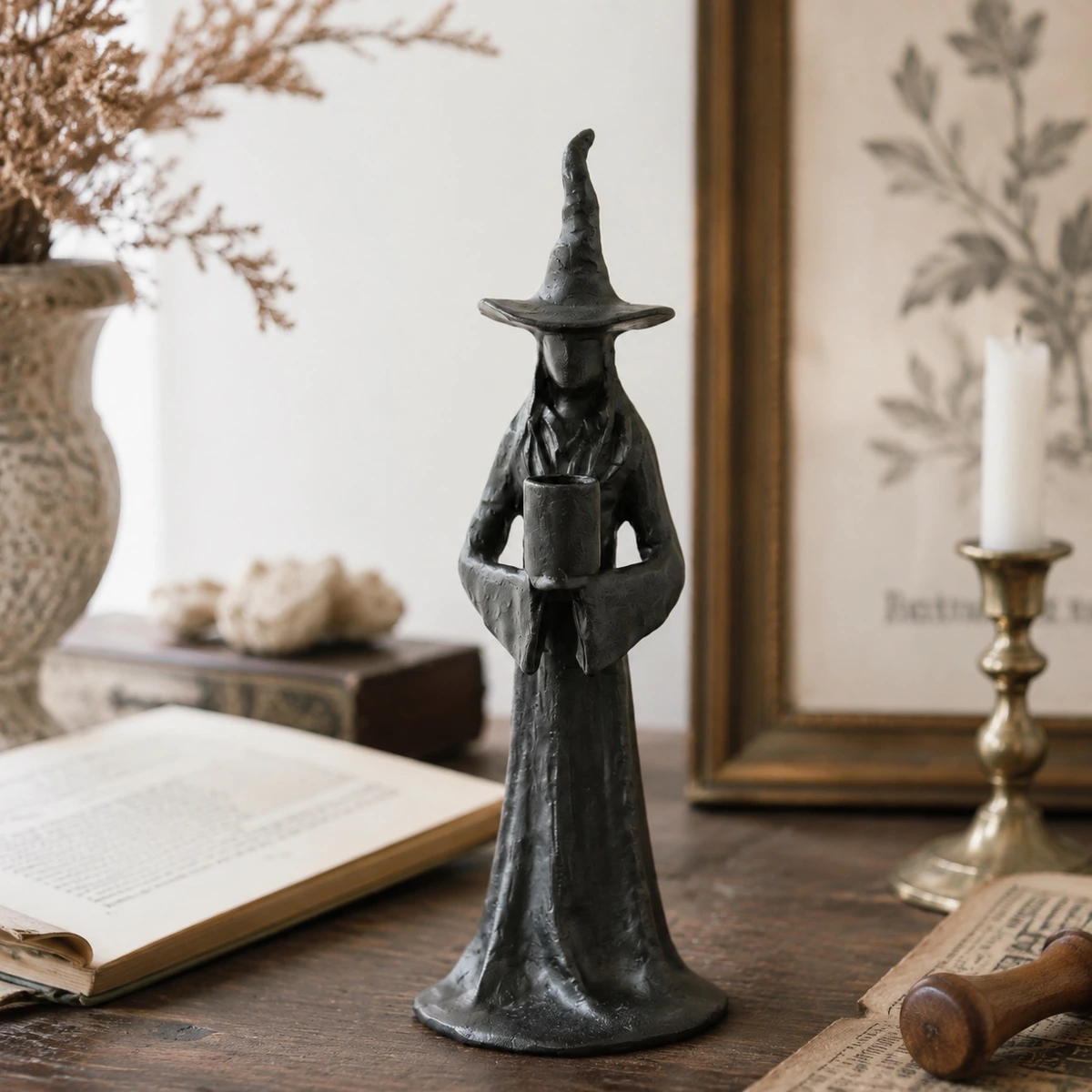 Single Candle Aura candlestick in a vintage tabletop setting with book and framed art