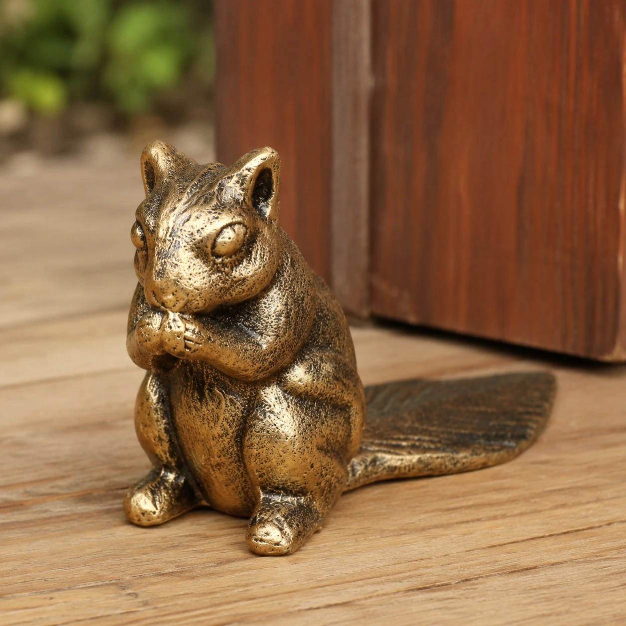 Guardian bronze cast iron door stopper in use by a wooden door