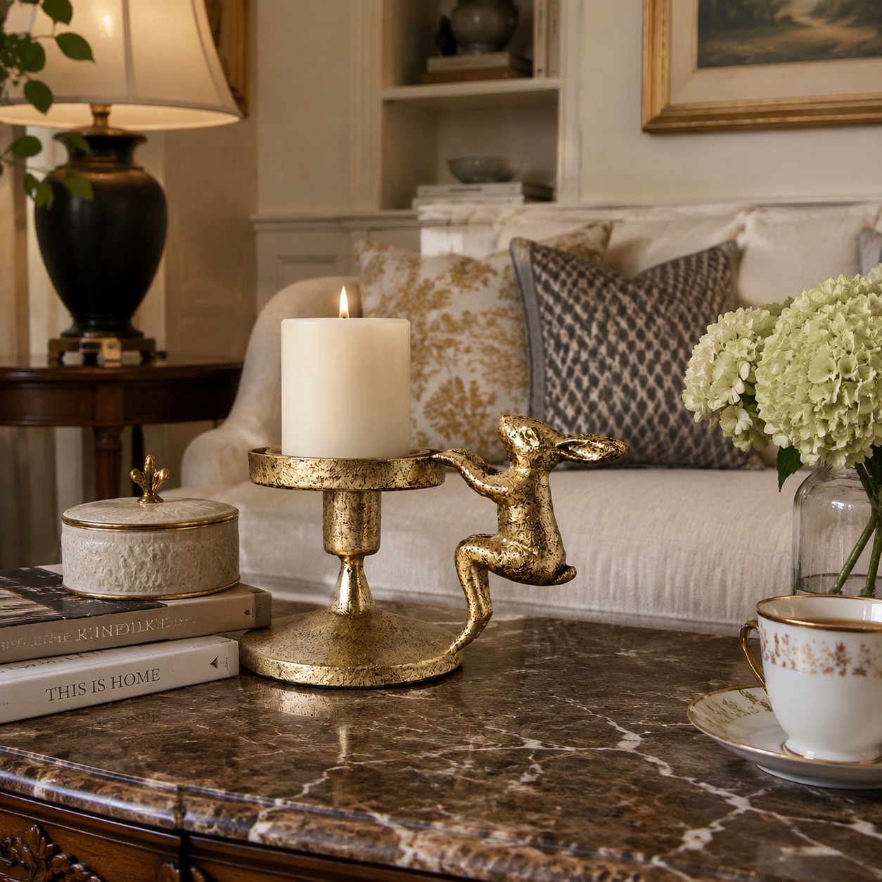 Aura gold metal candlestick holder styled with a pillar candle in a living room
