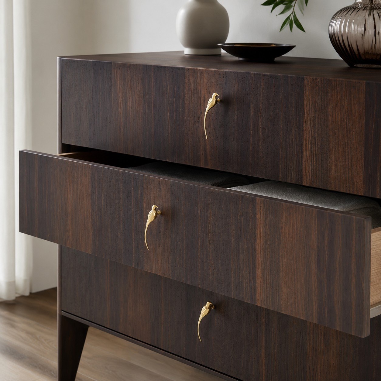 Totem brass handles on dark wood cabinet drawers
