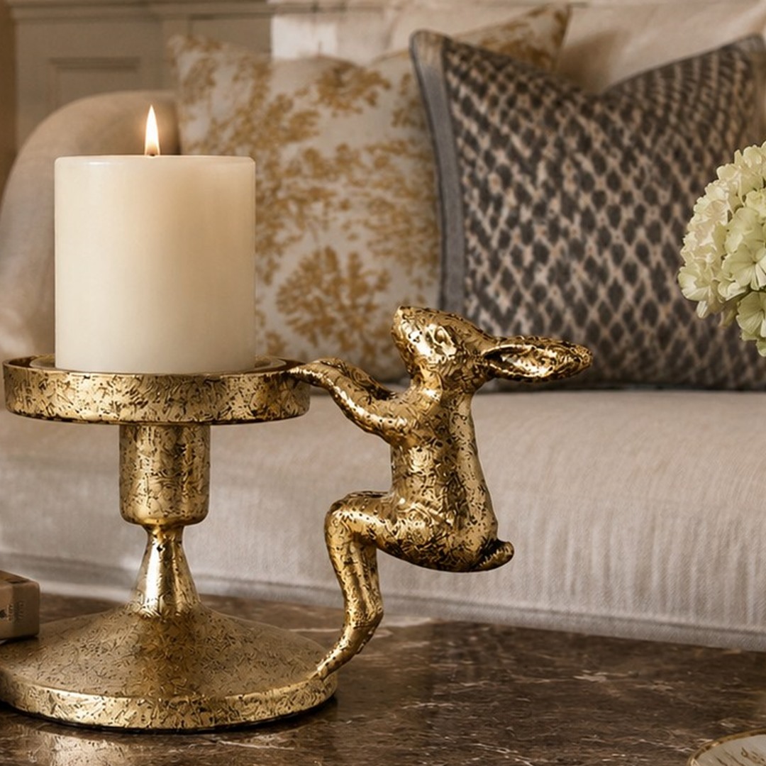 Aura candlestick holder shown in use with a lit candle