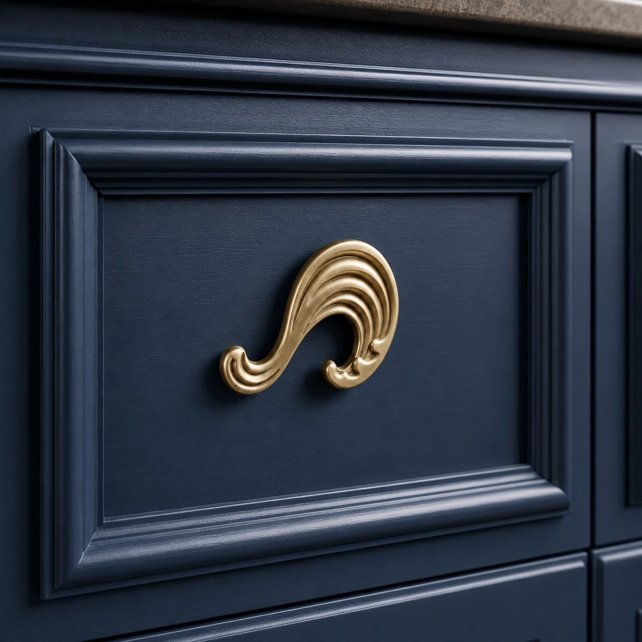 Natural brass Wave cabinet knob on a blue cabinet drawer