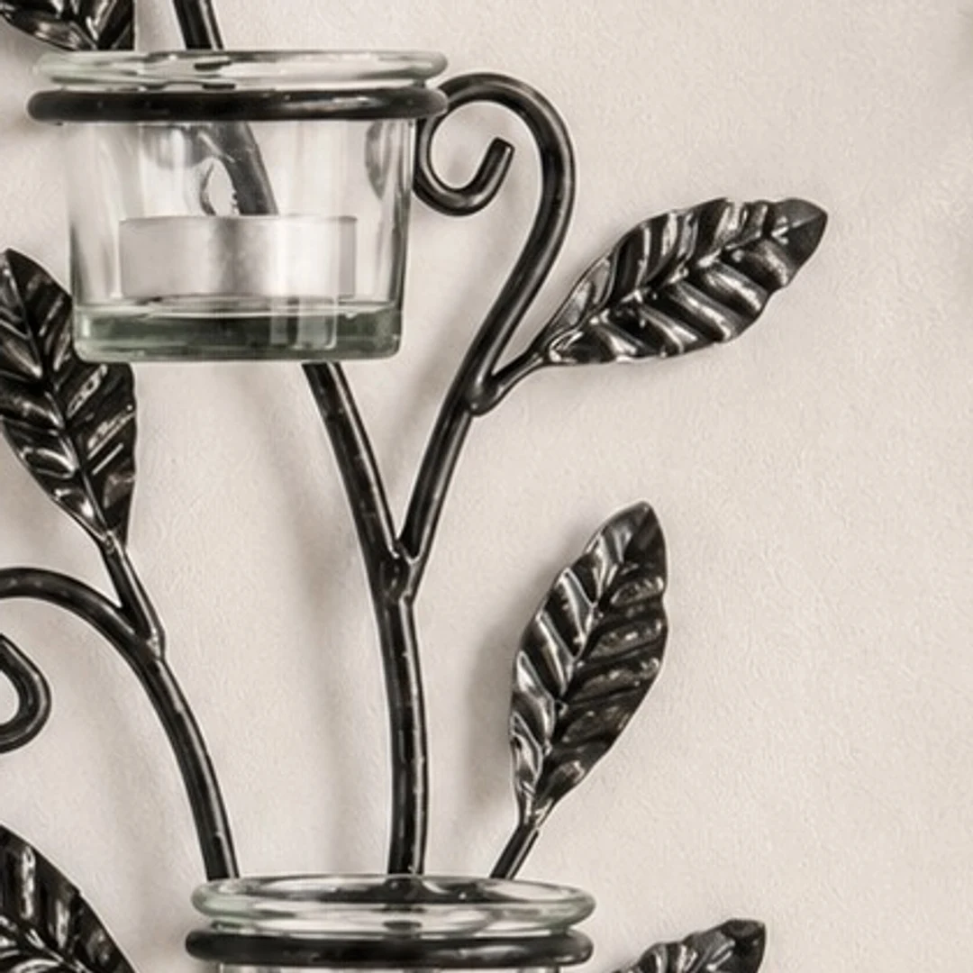 Close detail of clear glass candle cup and black iron holder