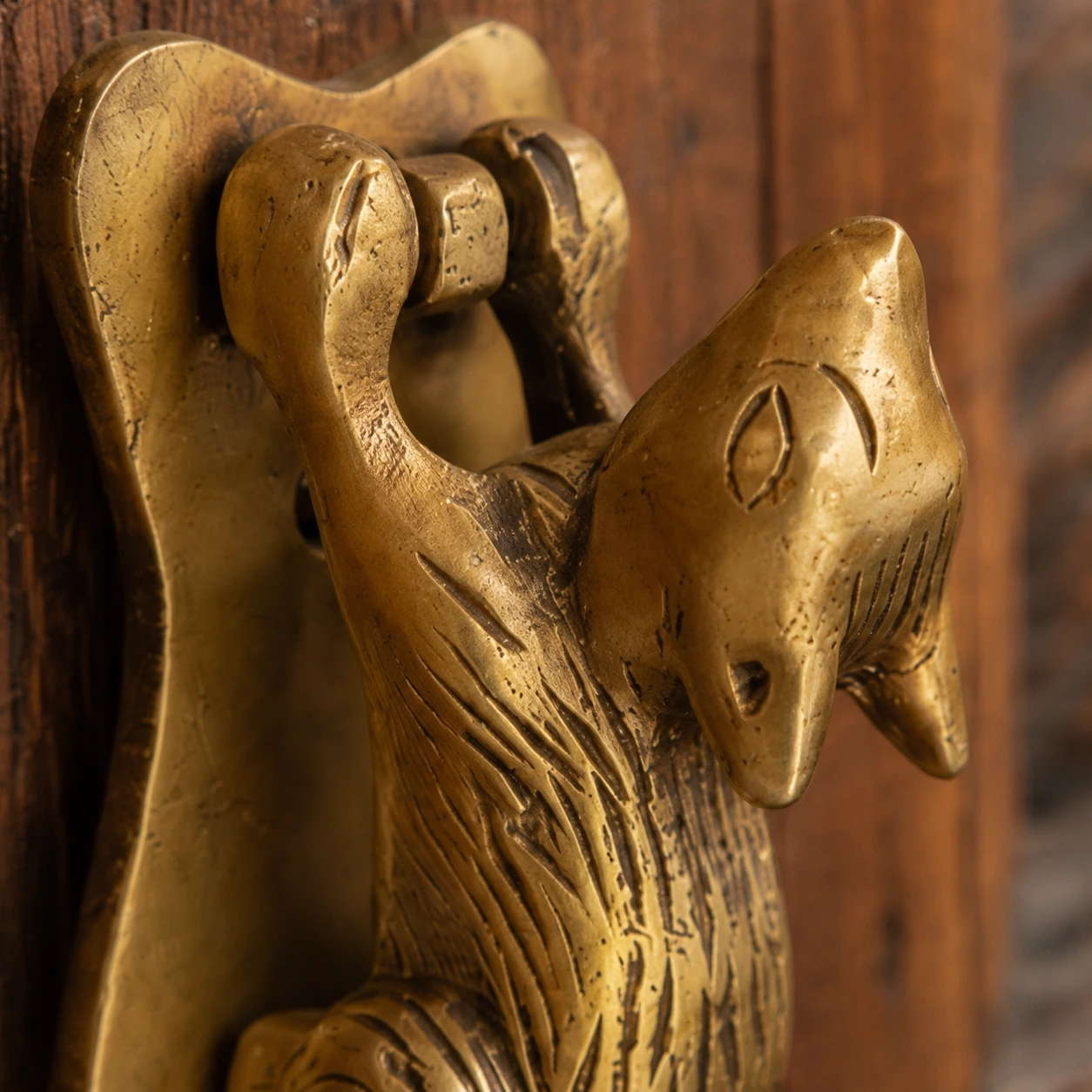 Close crop of the squirrel head and raised paws in aged brass