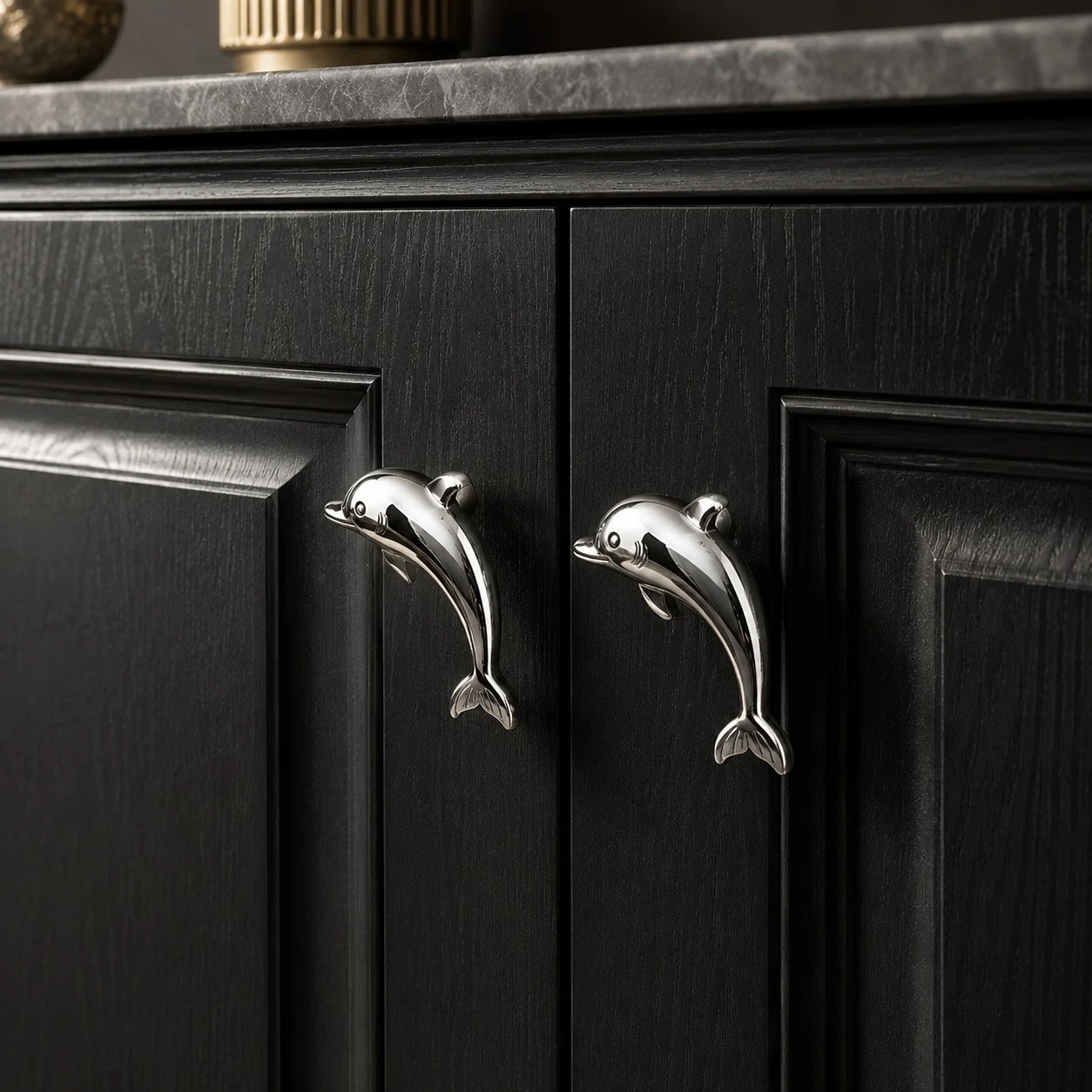 Chrome Dolphin cabinet pulls on a black cabinet