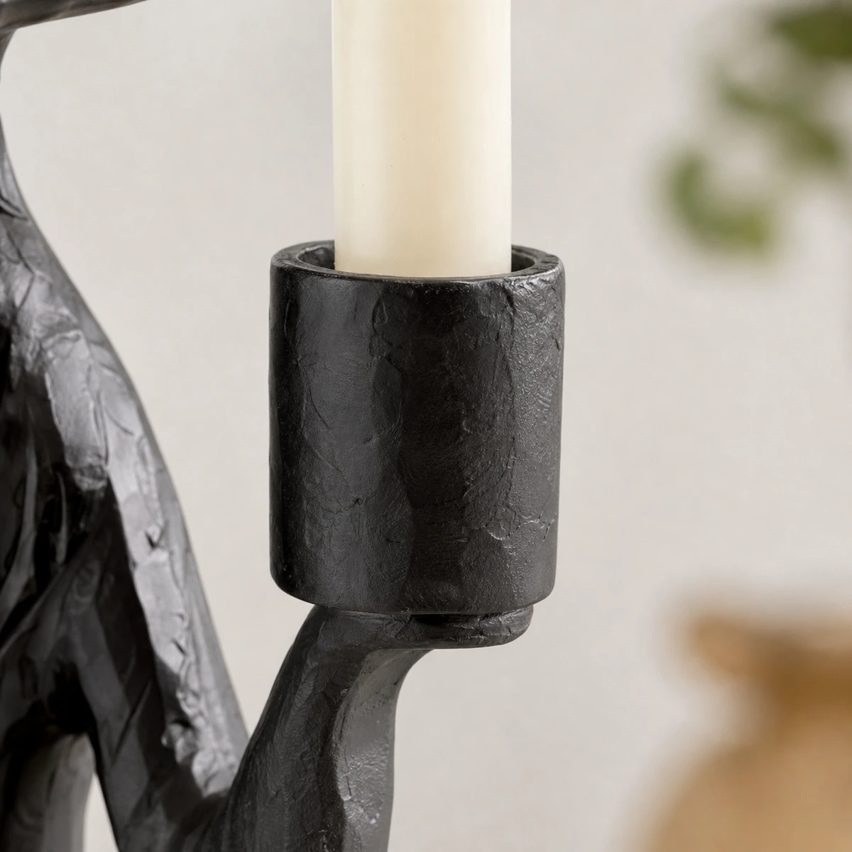 Close-up of the black resin candle cup and rim holding a taper candle