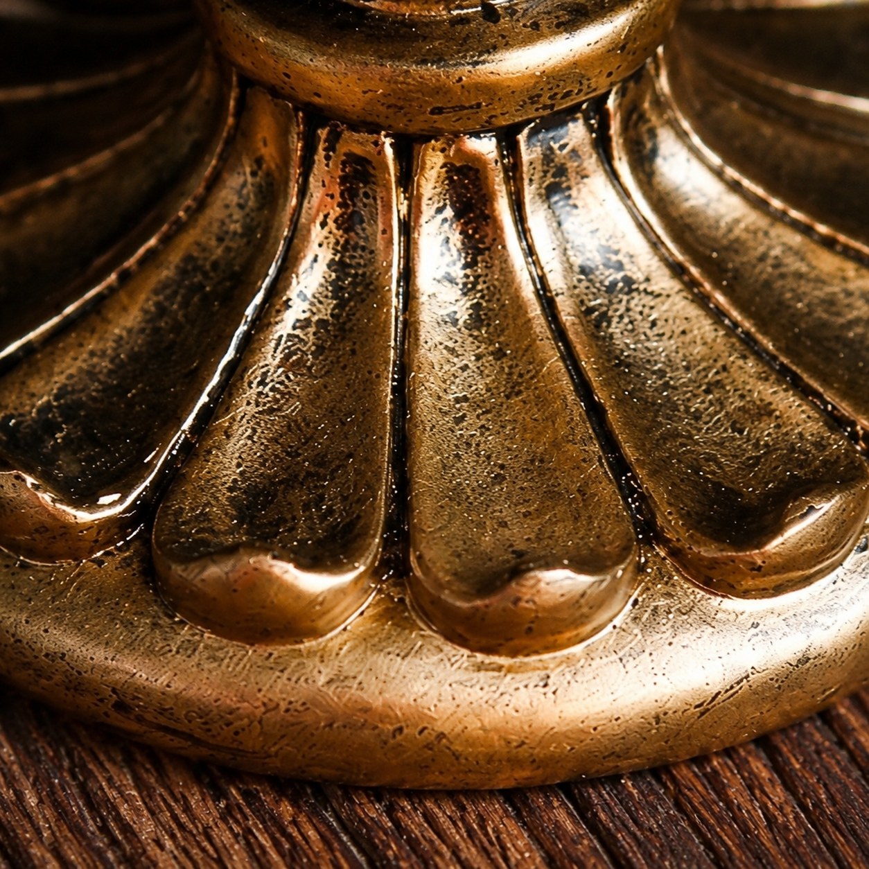 Close detail of Aura candlestick floral base grooves and copper texture