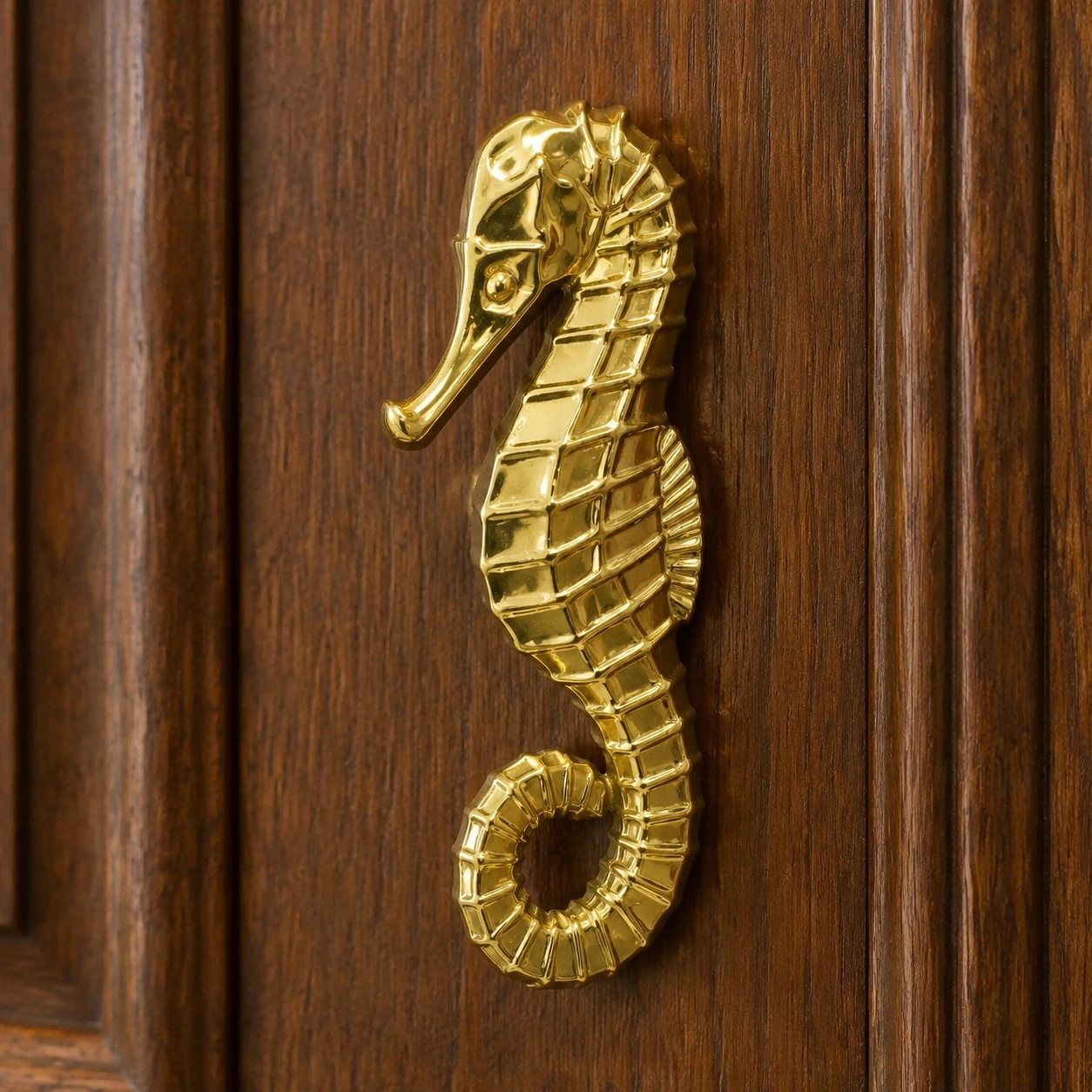 Right-facing Totem Haima brass seahorse cabinet handle on a clean background