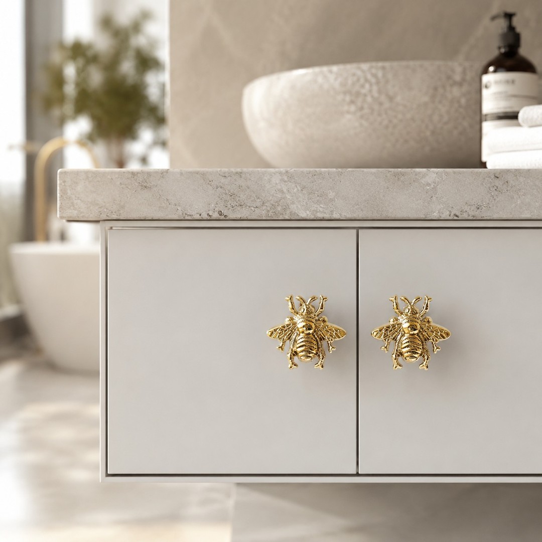 Gold Totem bee brass cabinet handle on a clean drawer front