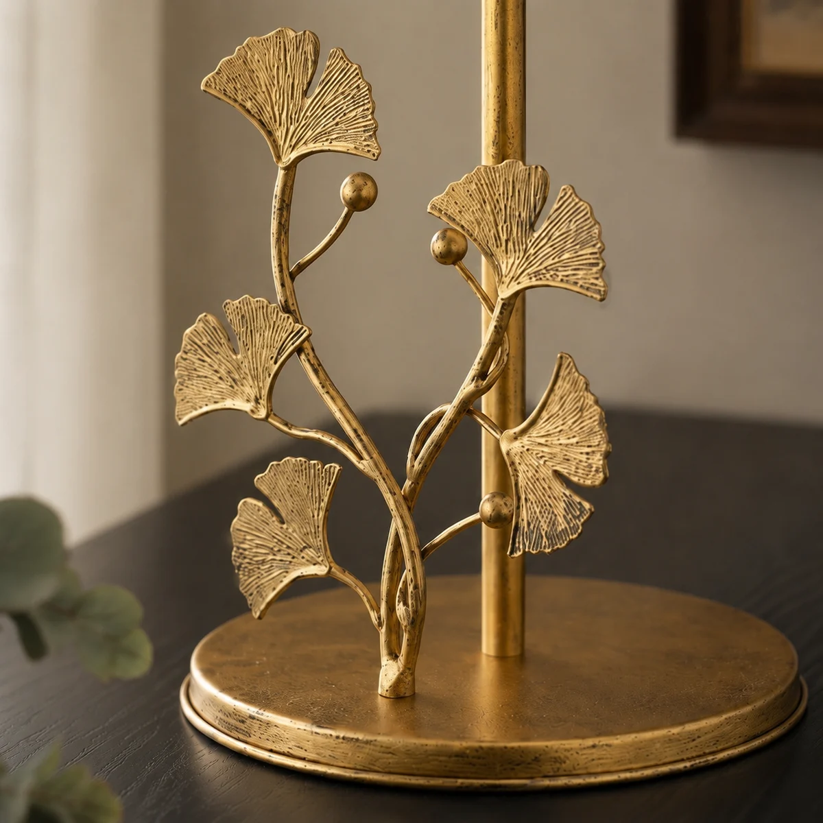 Close detail of the Forma brass ginkgo ornament and round base