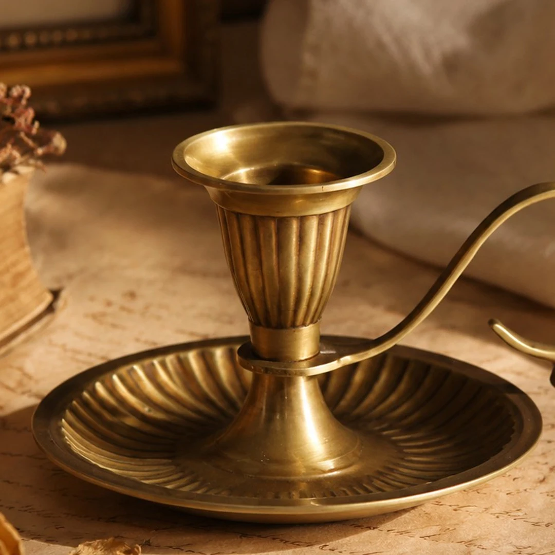 Close view of the Aura brass candlestick cup, stem, tray, and handle