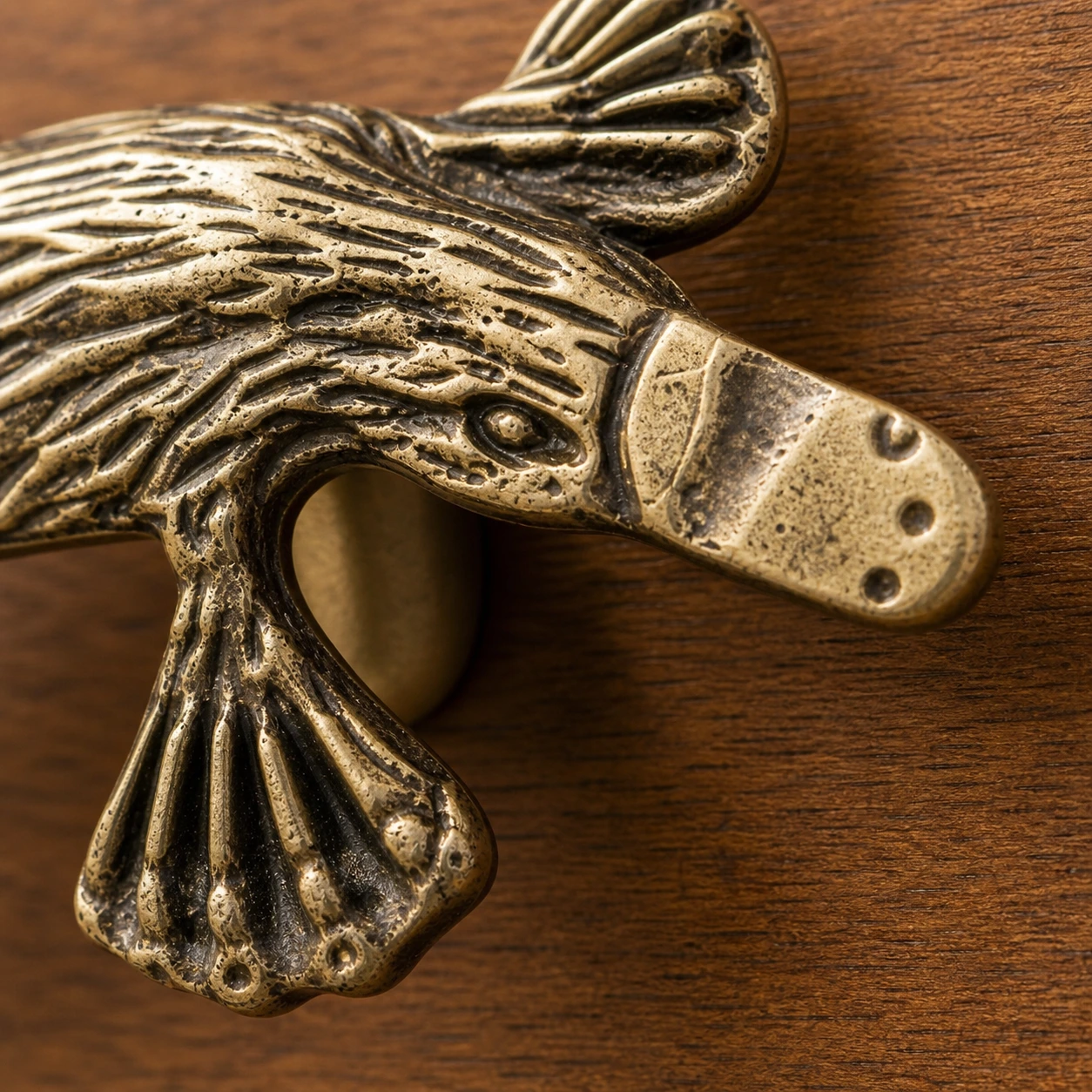 Macro detail of webbed foot and lower copper relief on Totem handle