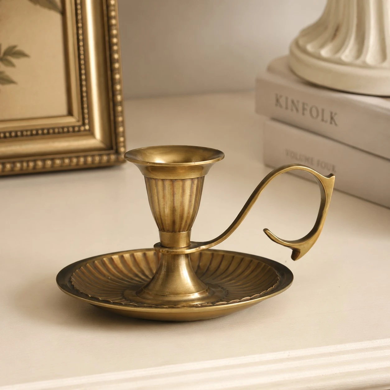 Aura brass candlestick holder on a styled tabletop
