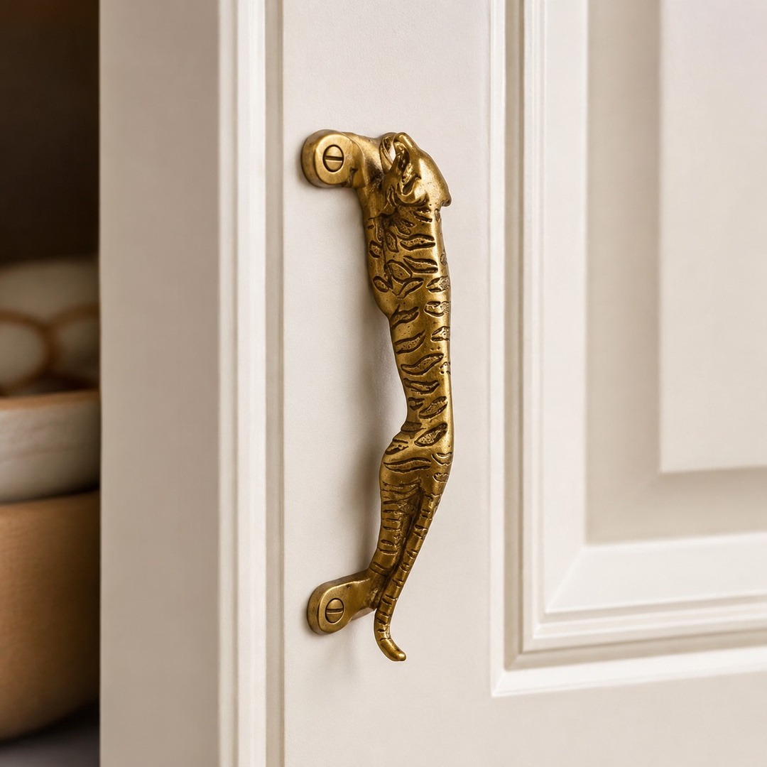 Leopard A brass cabinet handle on a white cabinet door