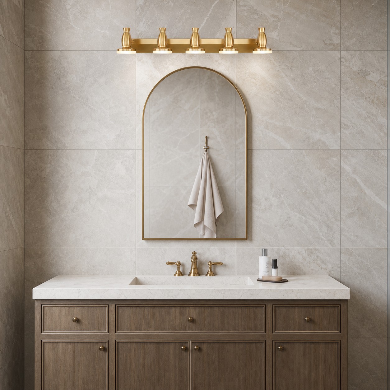Bravio brass vanity light over an arched mirror and stone wall