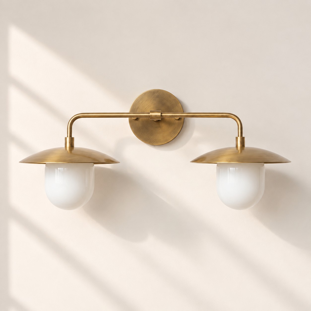 Sculptural Glass Wall Sconce with a brass finish and a metal wall mount