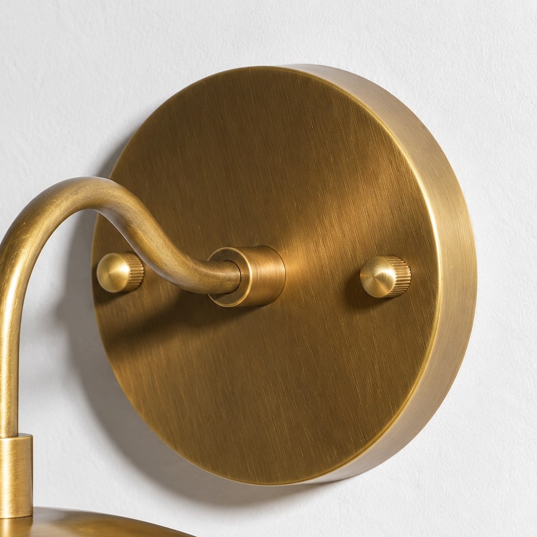 Sculptural Glass Wall Sconce with a brass finish and a metal wall mount