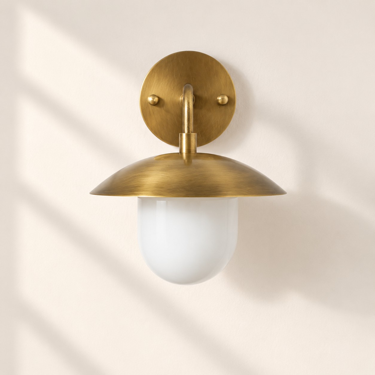 Sculptural Glass Wall Sconce with a brass finish and a metal wall mount