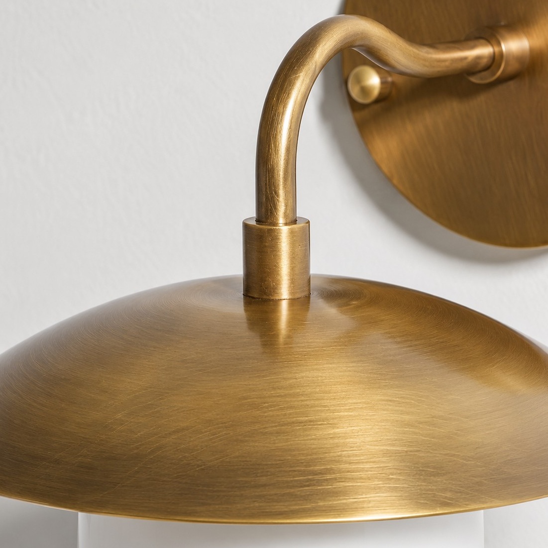 Sculptural Glass Wall Sconce with a brass finish and a metal wall mount