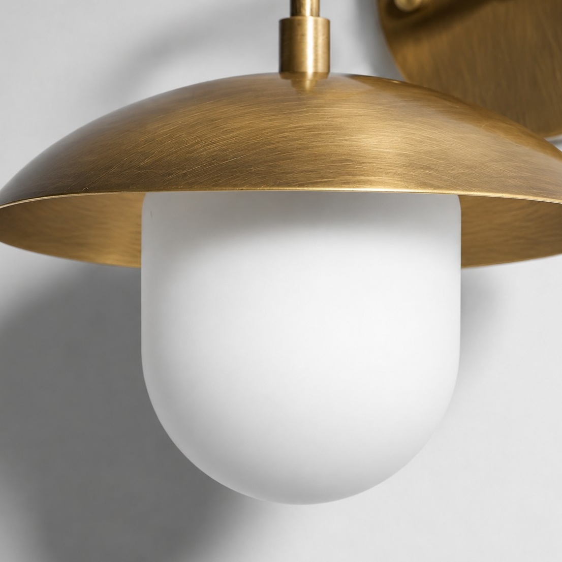 Sculptural Glass Wall Sconce with a brass finish and a metal wall mount