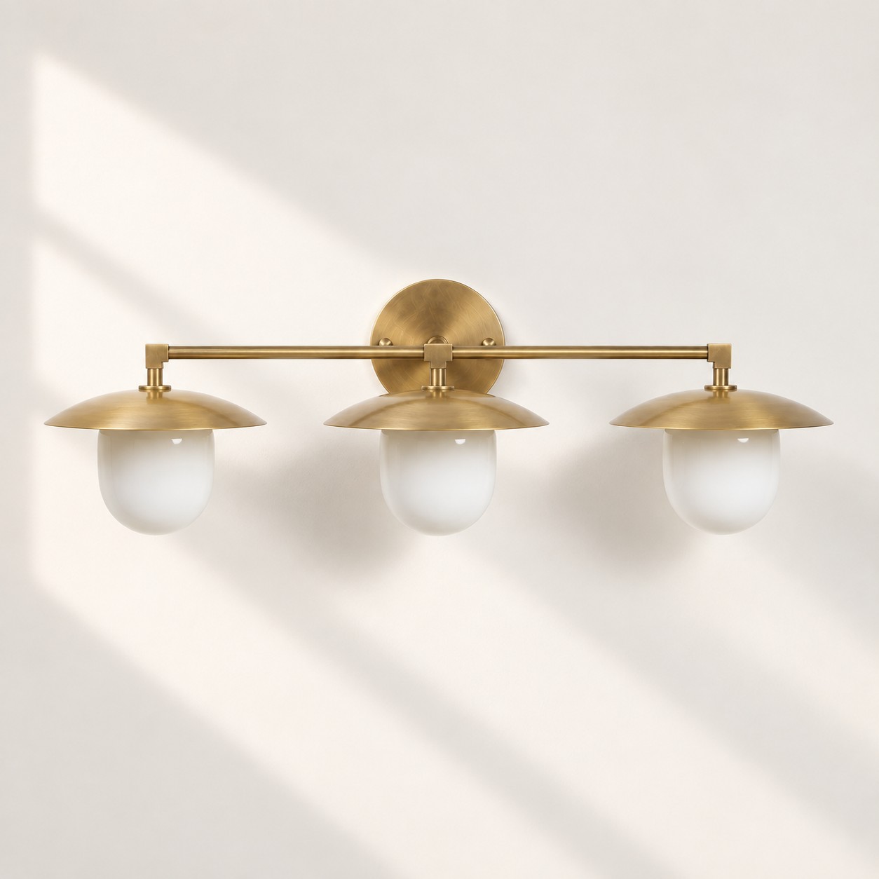 Sculptural Glass Wall Sconce with a brass finish and a metal wall mount