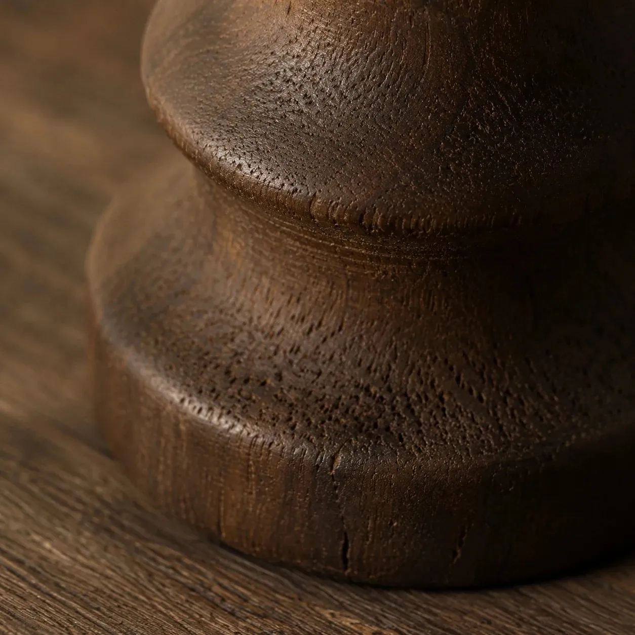 Close view of the dark carbonized wood base and turned contour