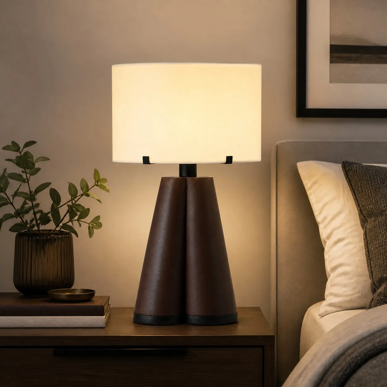 Brown leather table lamp glowing beside a bed