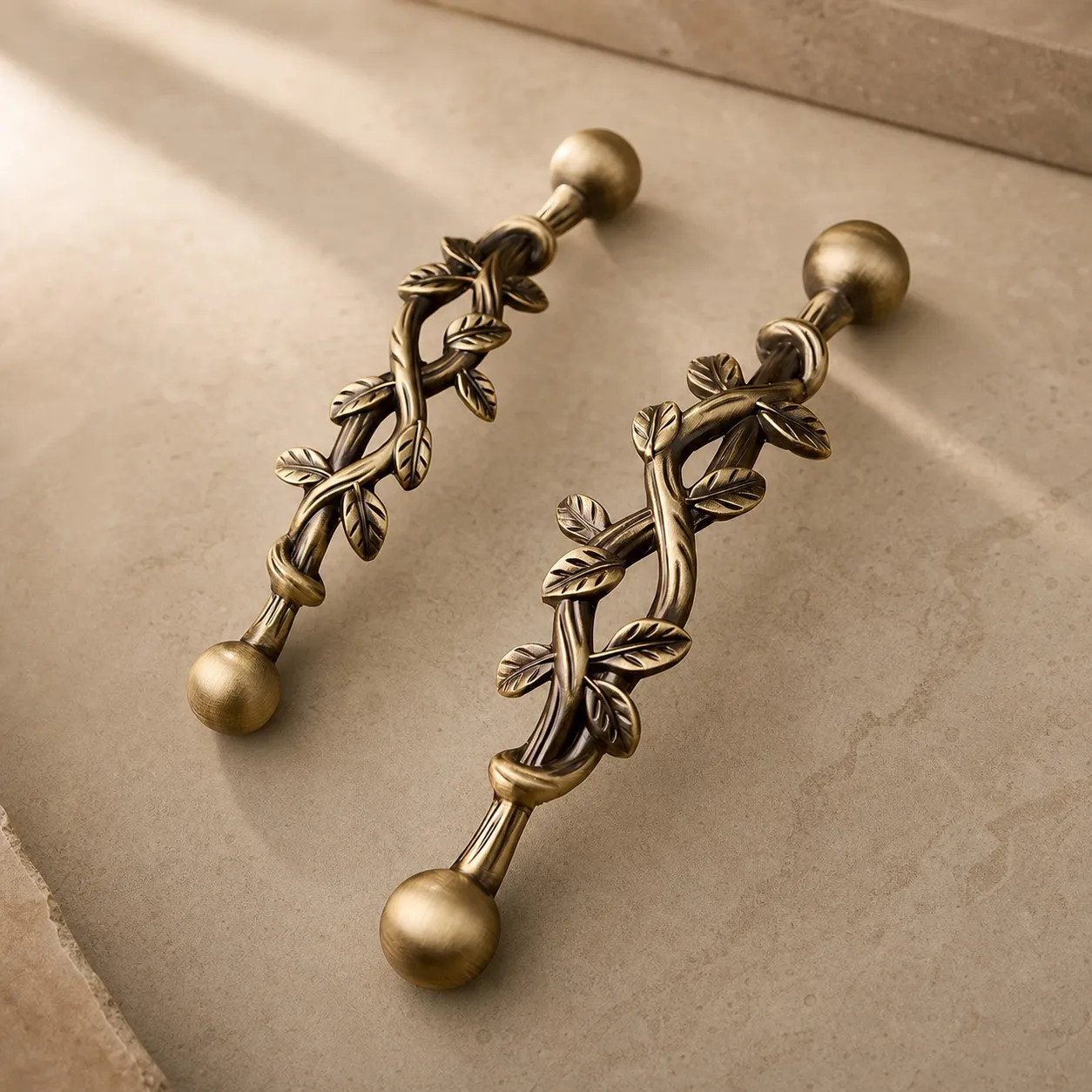 Pair of leaf brass cabinet pulls on a stone surface