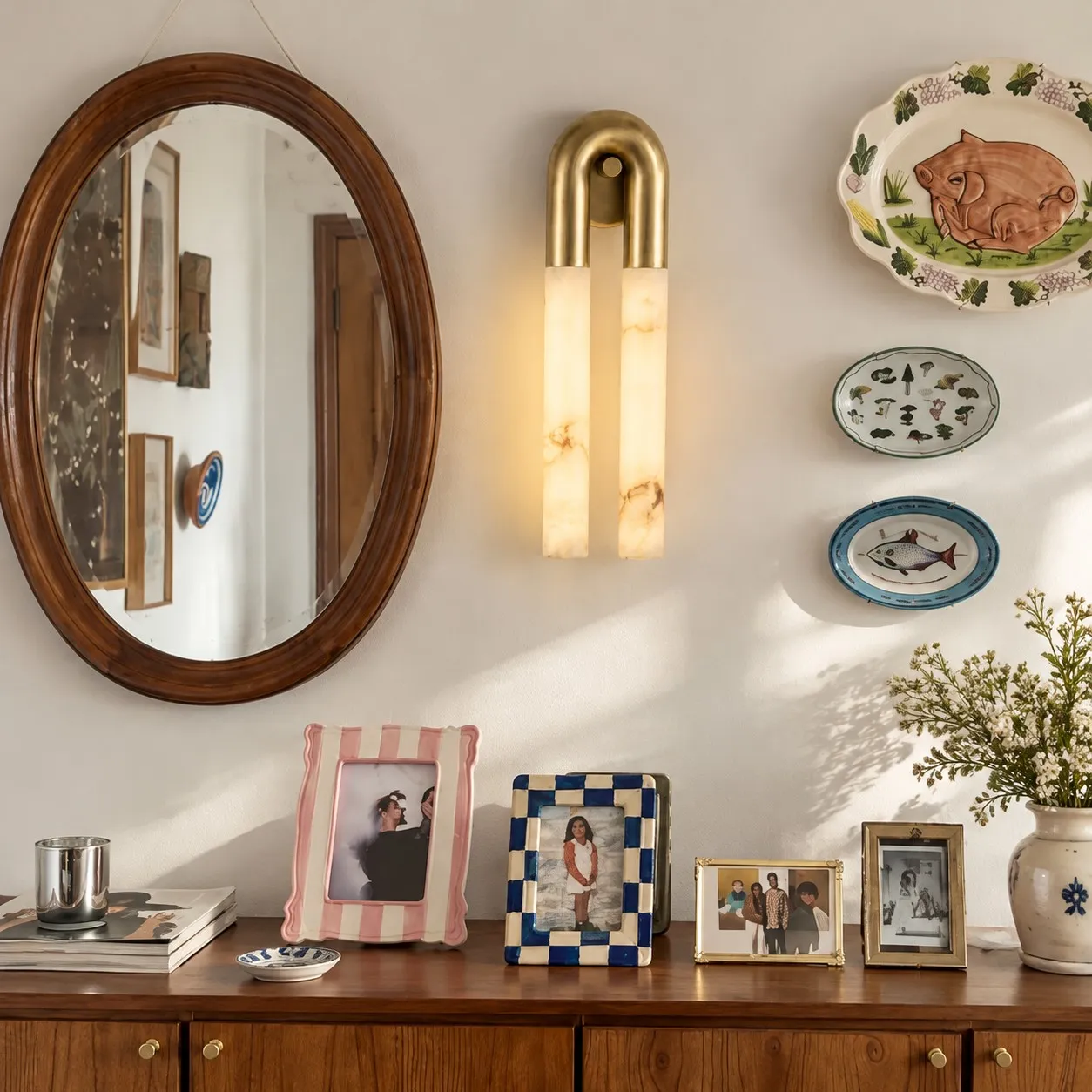 Velora brass alabaster wall light beside an oval mirror