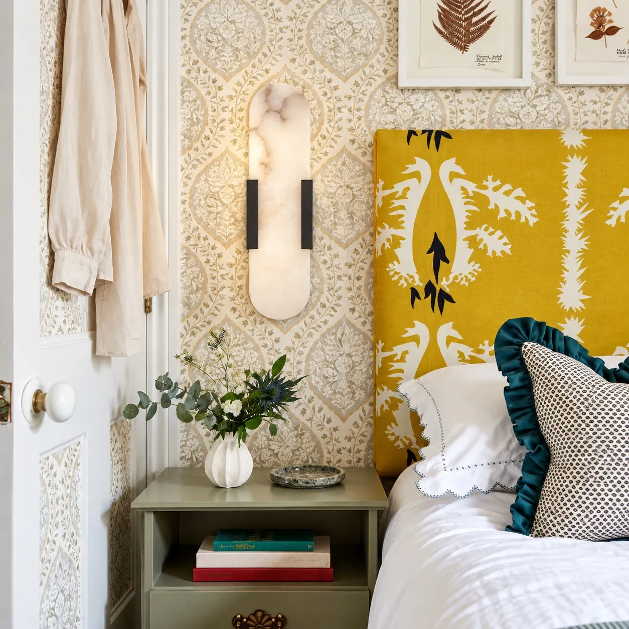 Velora black alabaster wall light beside a yellow headboard